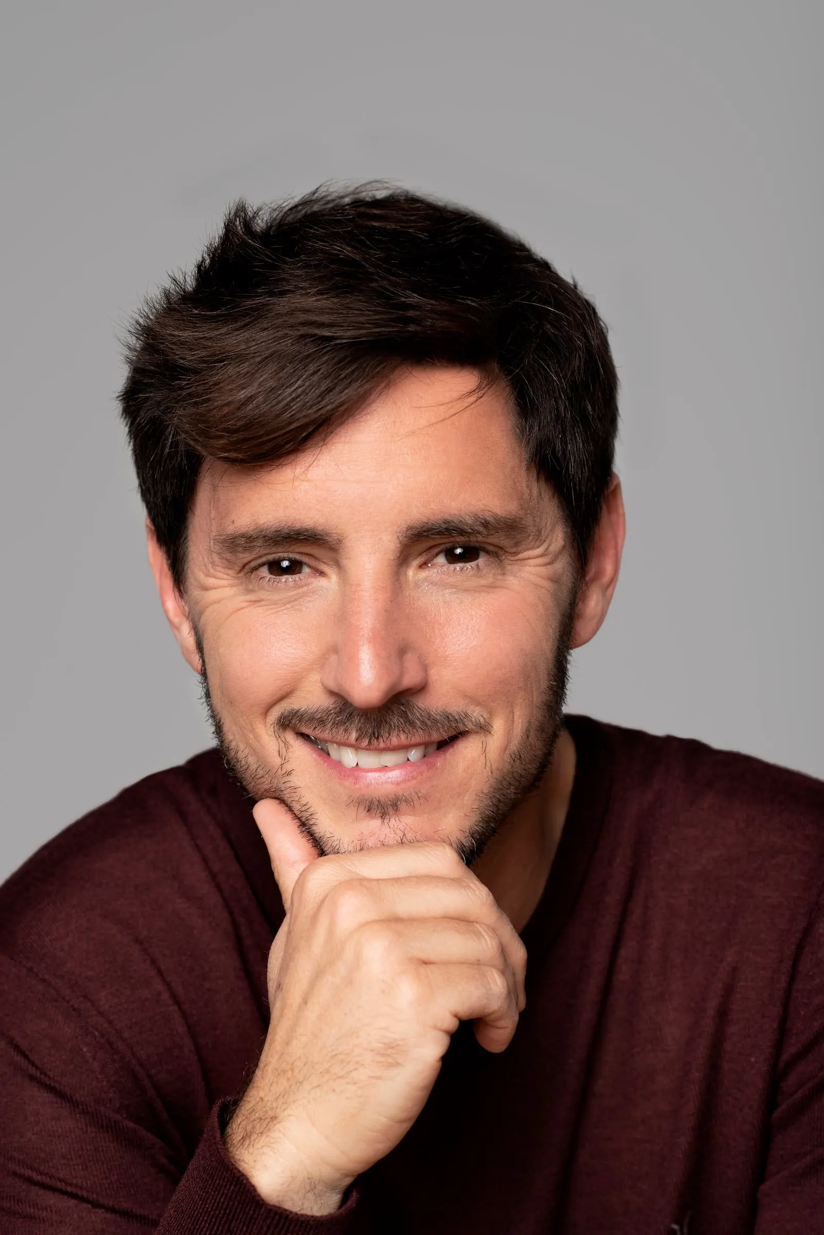 Bernardo Rivera, actor, sonriendo con jersey granate