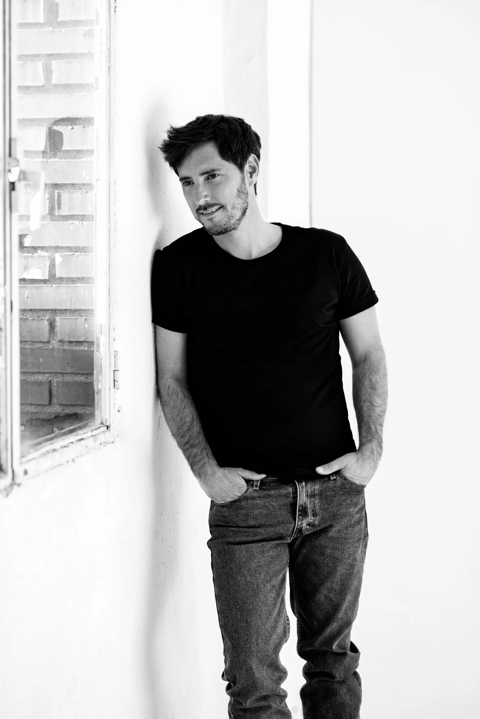 Bernardo Rivera, actor, en blanco y negro apoyado en una pared