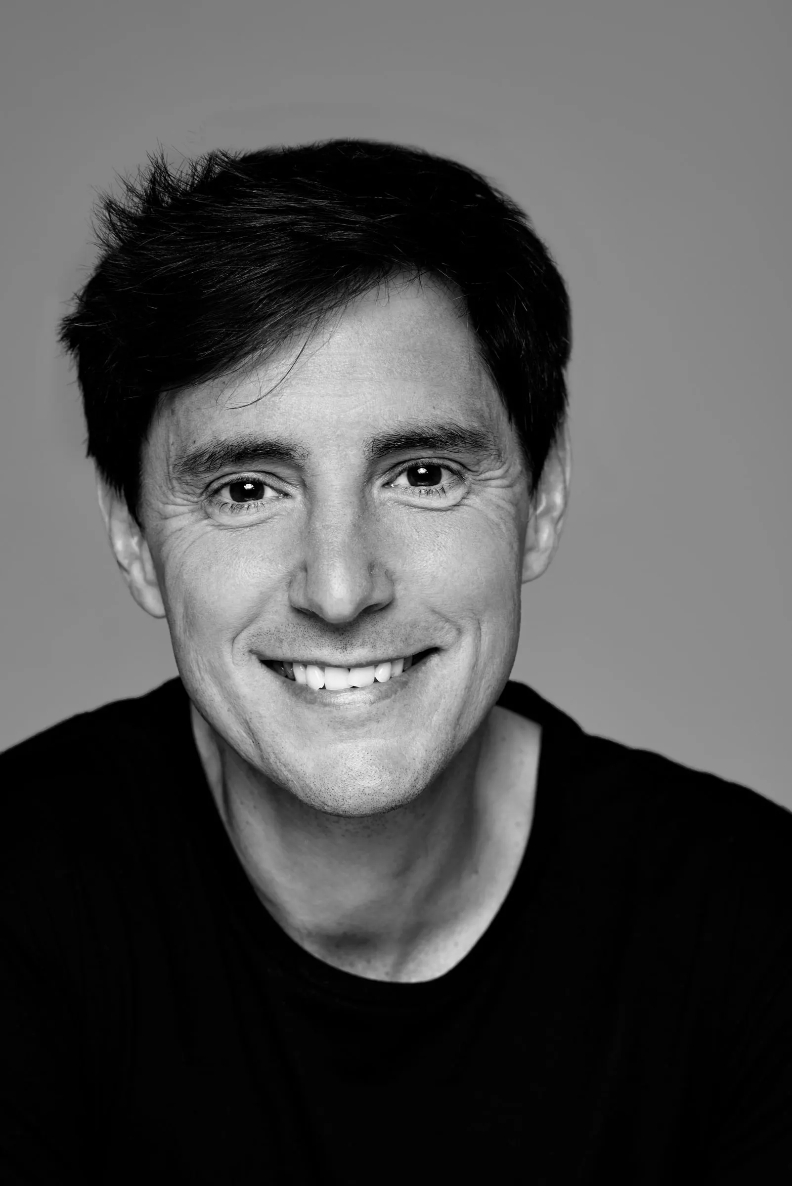 Bernardo Rivera en blanco y negro, primer plano sonriendo